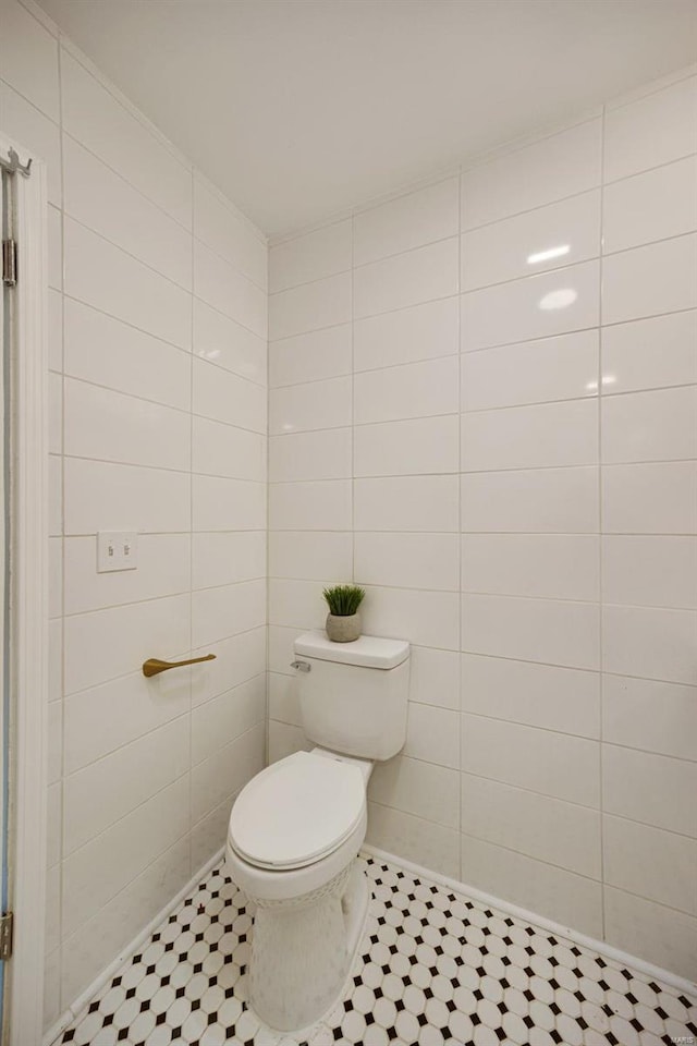 bathroom with tile patterned flooring, tile walls, and toilet