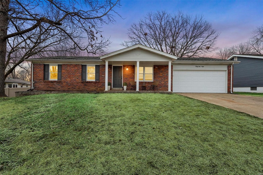 single story home with a garage and a lawn