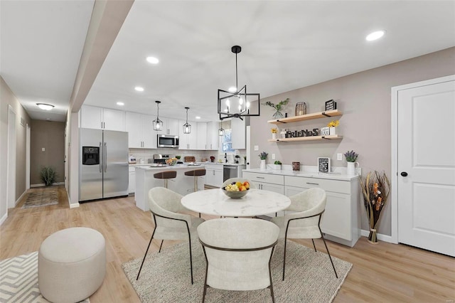 dining room with light hardwood / wood-style floors and a notable chandelier