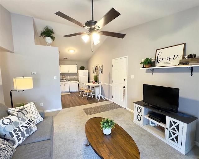 living area with baseboards, vaulted ceiling, a ceiling fan, and dark colored carpet