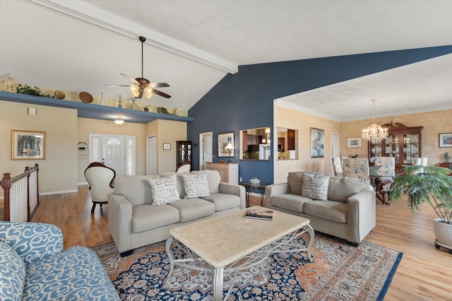 living area with baseboards, ornamental molding, beamed ceiling, light wood-type flooring, and ceiling fan with notable chandelier