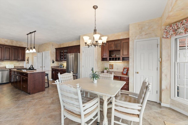 dining room featuring light tile patterned flooring, baseboards, and an inviting chandelier