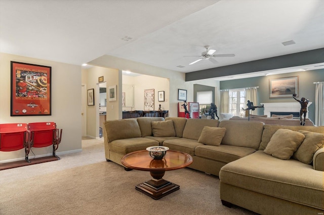 living area with light carpet, ceiling fan, and baseboards