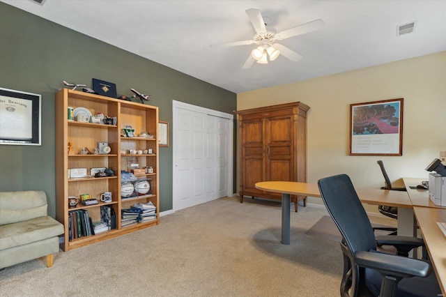 office featuring a ceiling fan, visible vents, and light colored carpet