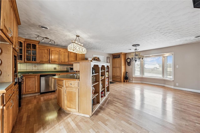 kitchen with wood finished floors, visible vents, a center island, dishwasher, and an inviting chandelier