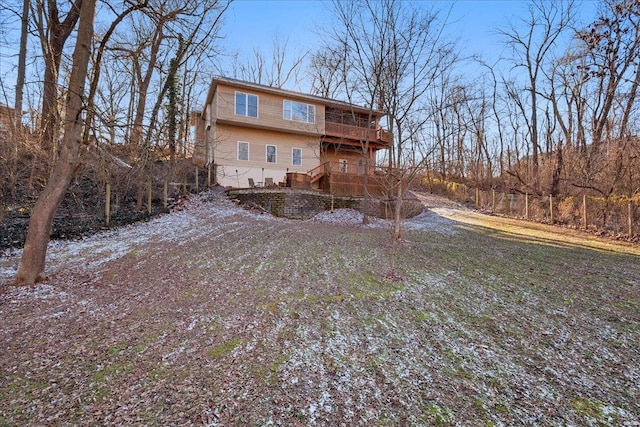 back of house featuring a wooden deck, a yard, and a balcony