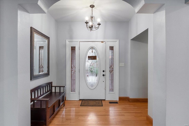 foyer with a notable chandelier and light hardwood / wood-style flooring