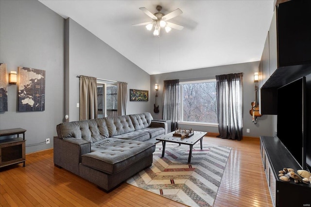 living room featuring high vaulted ceiling, light hardwood / wood-style floors, and ceiling fan