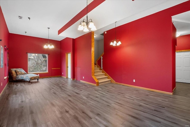 interior space with an inviting chandelier, wood-type flooring, and high vaulted ceiling