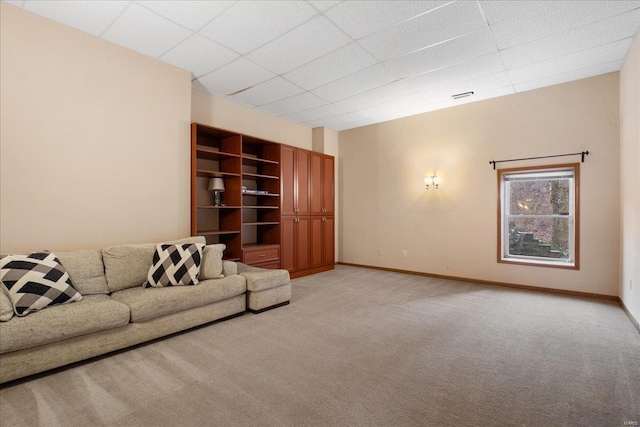 carpeted living room featuring a drop ceiling