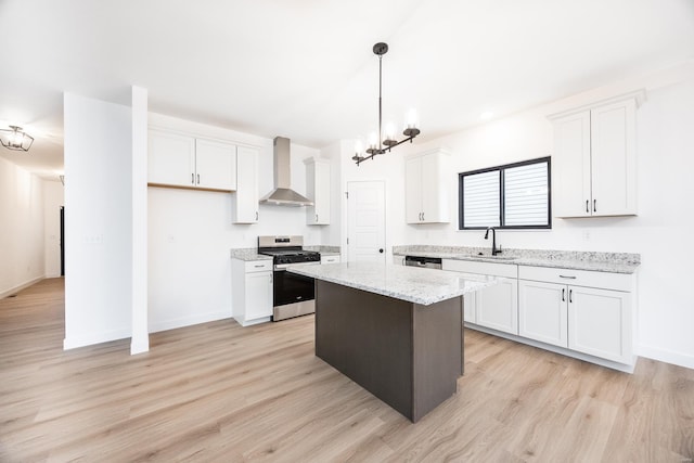 kitchen with white cabinetry, wall chimney range hood, a center island, and stainless steel gas range oven