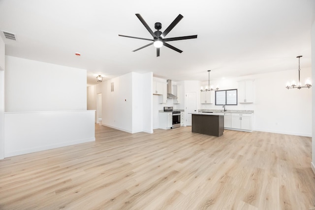 unfurnished living room featuring sink, ceiling fan with notable chandelier, and light hardwood / wood-style floors