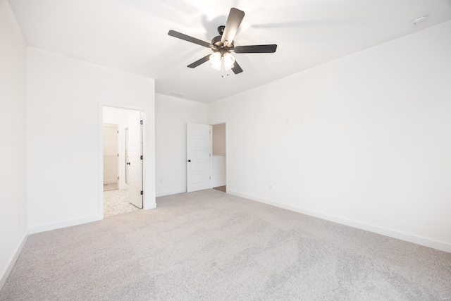 unfurnished bedroom featuring connected bathroom, light colored carpet, and ceiling fan