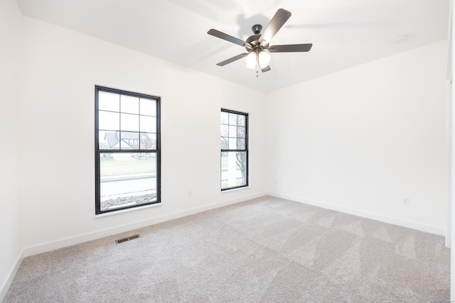 carpeted spare room featuring ceiling fan