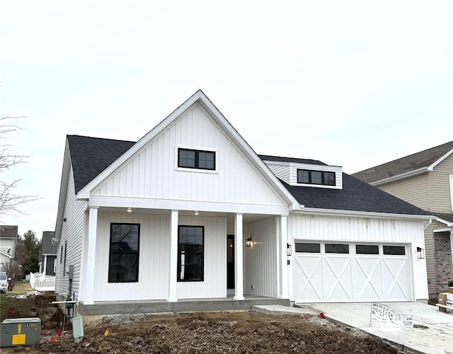 modern inspired farmhouse featuring a garage and a porch