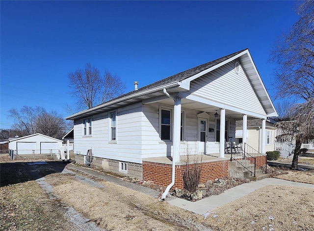 bungalow featuring a porch and an outdoor structure