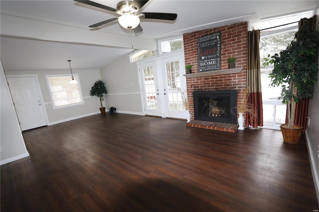 unfurnished living room with lofted ceiling with beams, plenty of natural light, dark wood finished floors, and baseboards