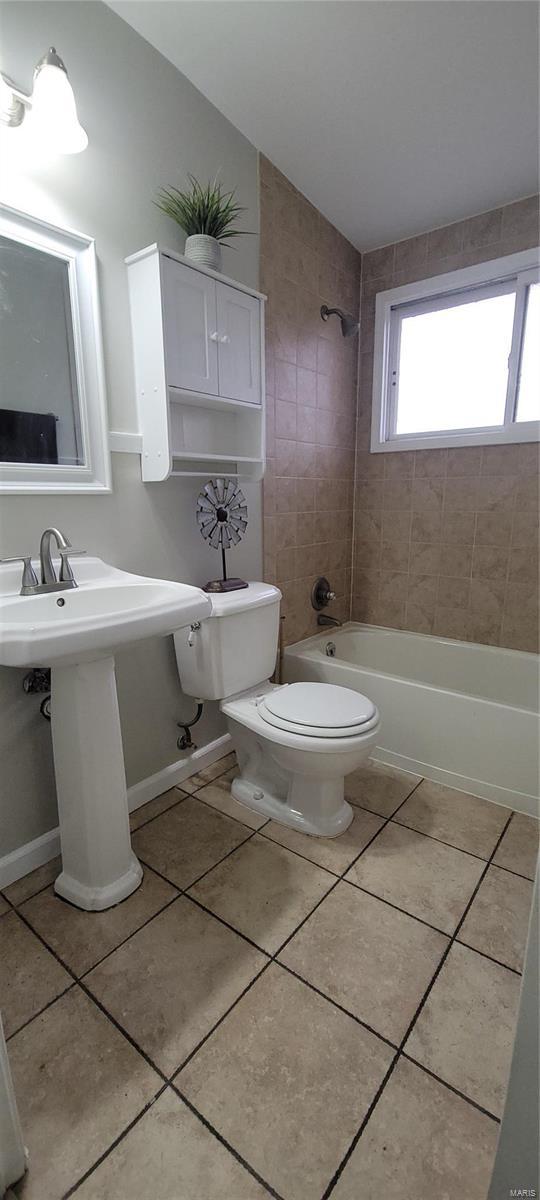 bathroom featuring vaulted ceiling, tub / shower combination, toilet, and tile patterned floors