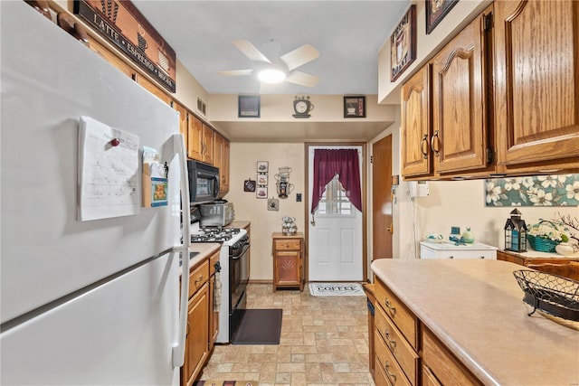 kitchen featuring gas stove, white fridge, and ceiling fan