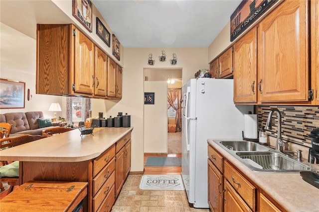 kitchen with tasteful backsplash, white fridge, and sink