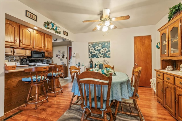 dining area with ceiling fan and light wood-type flooring