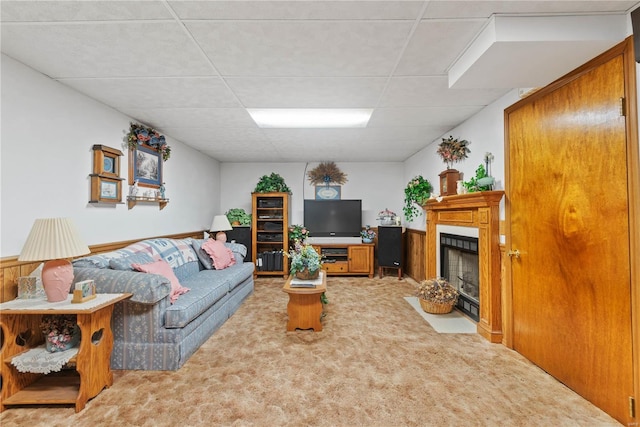 carpeted living room featuring a drop ceiling