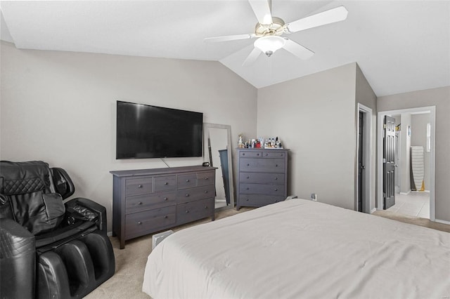 bedroom featuring ceiling fan, ensuite bathroom, vaulted ceiling, and light carpet