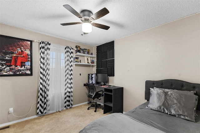 carpeted bedroom with ceiling fan and a textured ceiling