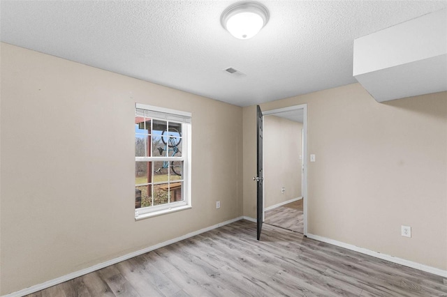 unfurnished bedroom with a textured ceiling and light hardwood / wood-style floors