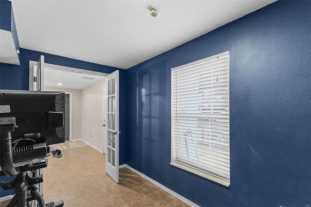 office area featuring tile patterned flooring, french doors, and a textured ceiling