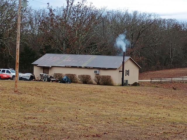 view of home's exterior with a lawn, an AC wall unit, and central air condition unit