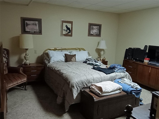 carpeted bedroom featuring a drop ceiling