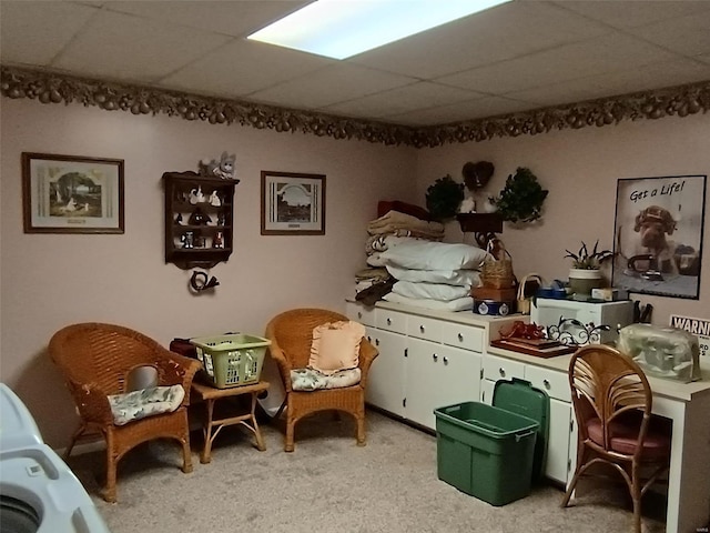 living area with a paneled ceiling and light colored carpet