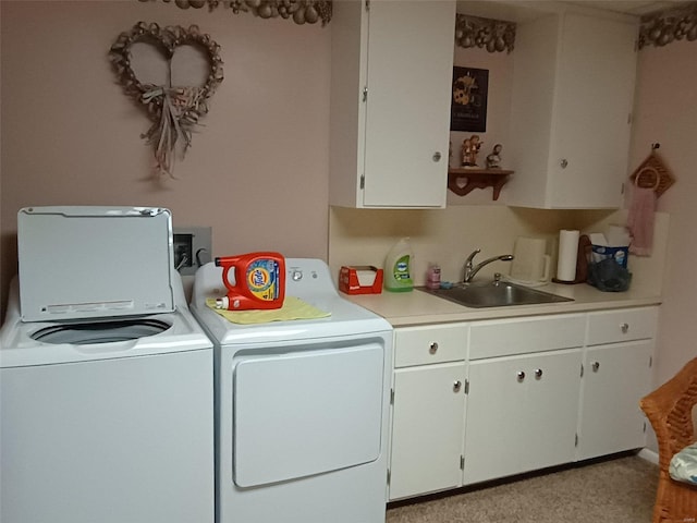 laundry room with sink, washing machine and dryer, and cabinets