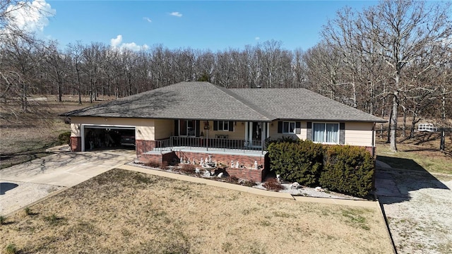 ranch-style house with covered porch, concrete driveway, roof with shingles, a garage, and brick siding