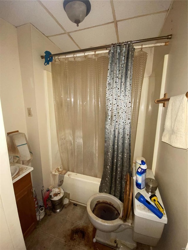 full bathroom featuring a drop ceiling, shower / bath combination with curtain, tile patterned floors, and toilet