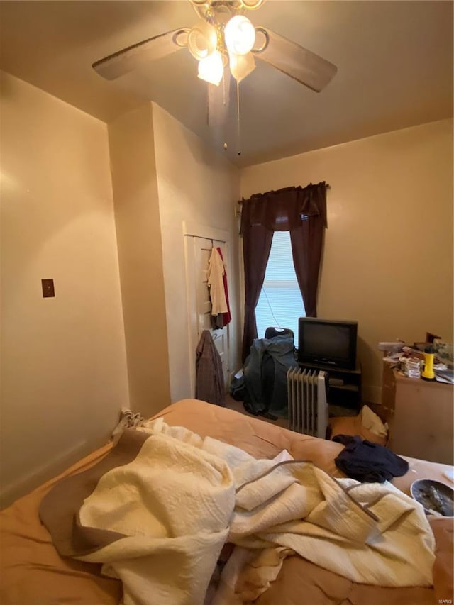 bedroom with radiator heating unit and ceiling fan