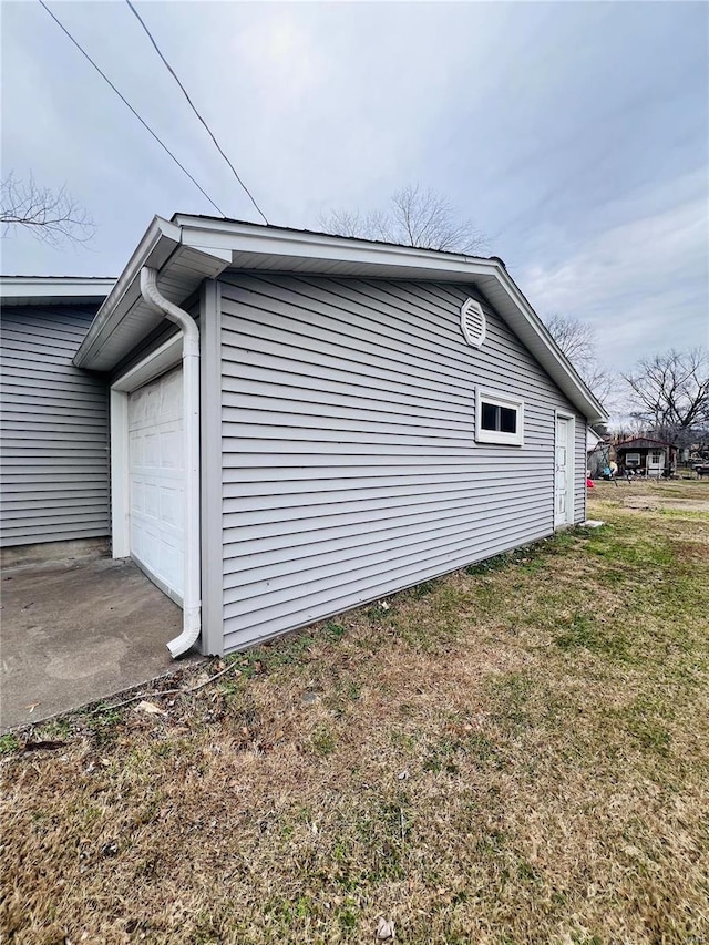 view of side of property with a garage and a yard