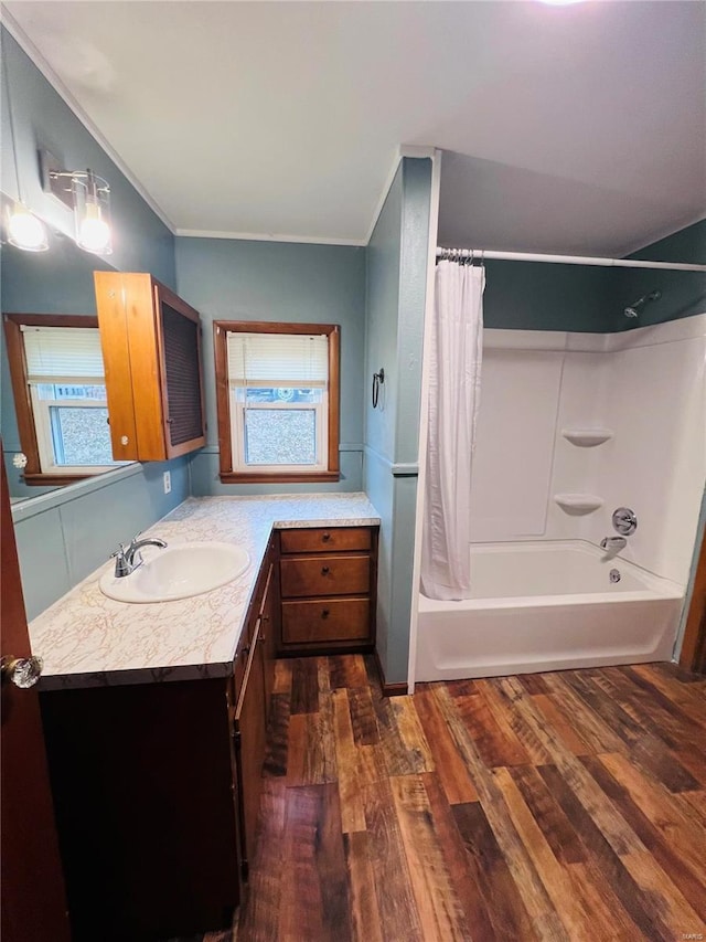 bathroom featuring shower / bathtub combination with curtain, hardwood / wood-style floors, vanity, a wealth of natural light, and ornamental molding