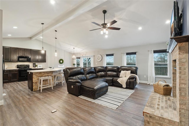 living room with ceiling fan, light hardwood / wood-style flooring, lofted ceiling with beams, and a wealth of natural light