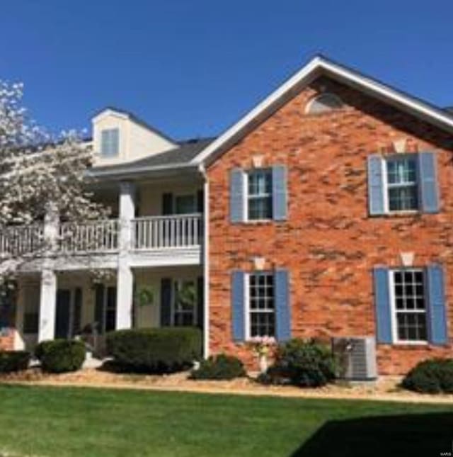 view of front facade featuring a front lawn and a balcony