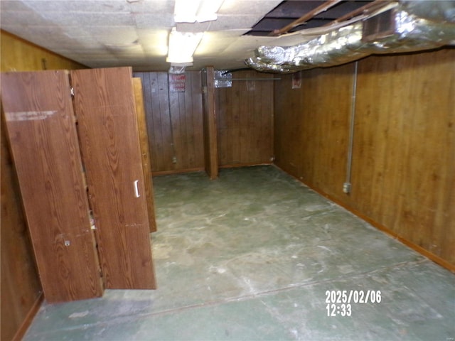 basement featuring wooden walls