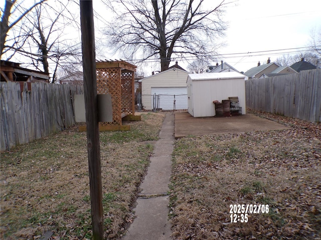 view of yard featuring an outbuilding, a garage, and a patio