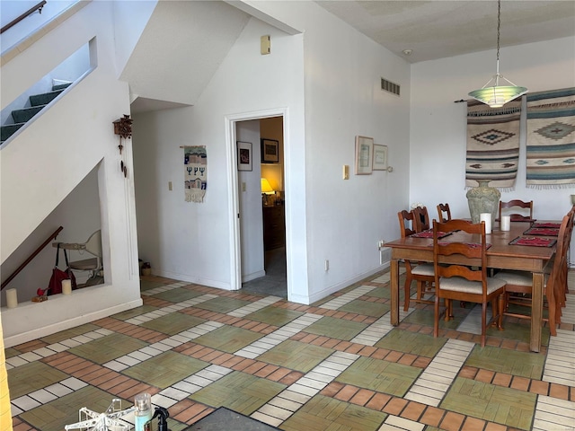 dining space with high vaulted ceiling