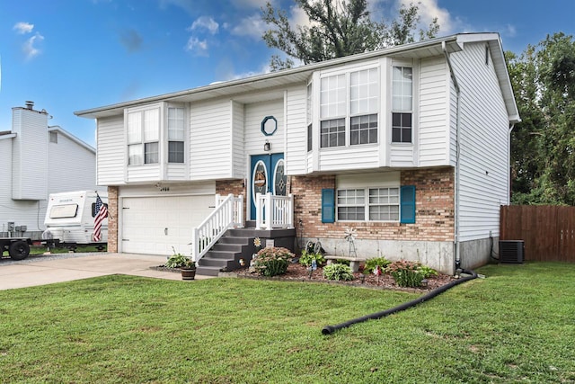 split foyer home with central AC, a garage, and a front lawn