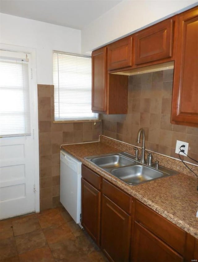 kitchen with a healthy amount of sunlight, dishwasher, sink, and tile walls