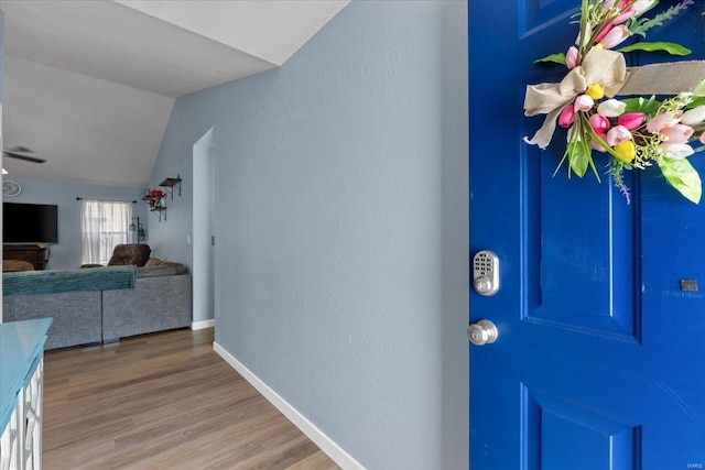 entrance foyer with lofted ceiling, light wood-type flooring, and baseboards