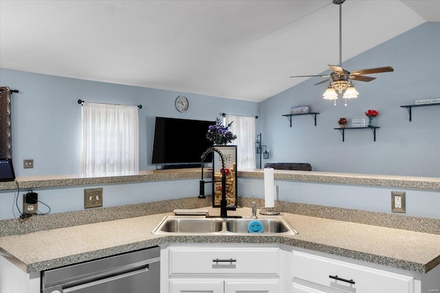 kitchen with a sink, white cabinets, vaulted ceiling, and stainless steel dishwasher