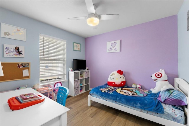 bedroom with a ceiling fan and light wood-style flooring