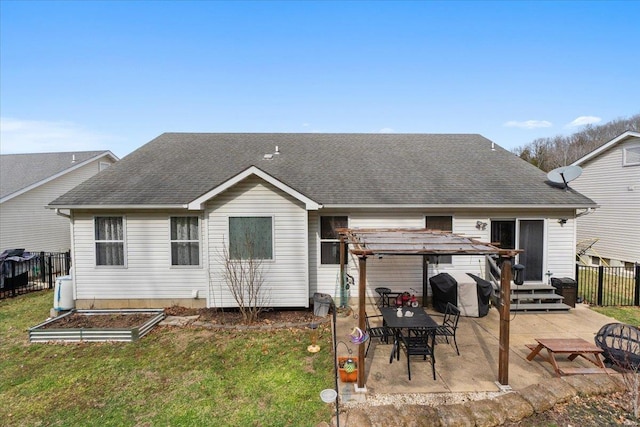 back of house featuring a yard, a shingled roof, a patio, and fence